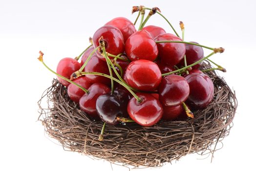 Sweet red cherries in a nest isolated on a white background