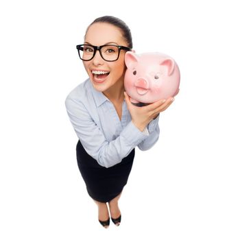 business, banking, investment and office concept - laughing businesswoman in eyeglasses with piggy bank