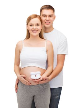 pregnancy, parenthood and happiness concept - happy young family expecting child