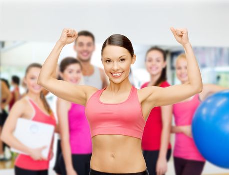 fitness, sport, training and lifestyle concept - personal trainer with group of smiling people in gym