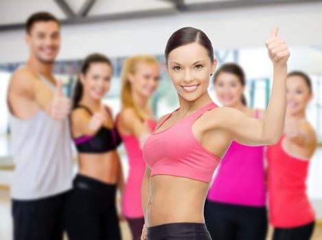fitness, sport, training and lifestyle concept - personal trainer with group of smiling people in gym