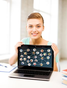 technology and social networking concept - smiling student girl with laptop at school