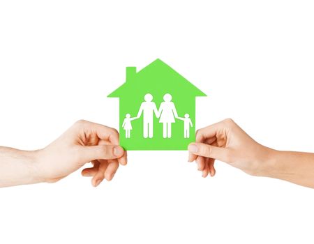 real estate and family home concept - isolated picture of male and female hands holding green paper house with family