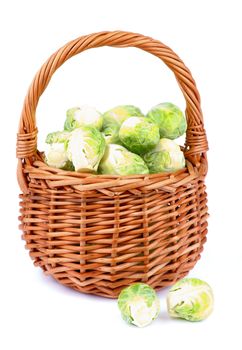 Fresh Raw Brussels Sprouts in Wicker Basket isolated on White background
