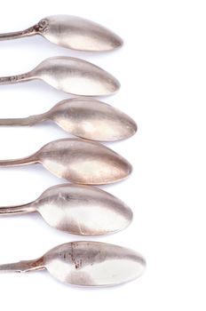 Frame of Old Silver Spoons In a Row isolated on white background