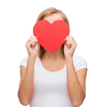 happiness, health and love concept - woman in white t-shirt covering her face with red heart