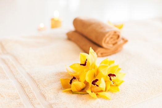 spa, health and beauty concept - closeup of towels, flowers and candles