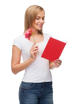 love, holidays and happiness concept - smiling girl with postcard and flower