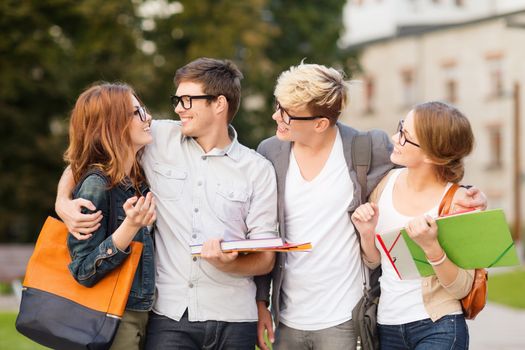 summer holidays, education, campus and teenage concept - group of students or teenagers with files, folders and eyeglasses hanging out