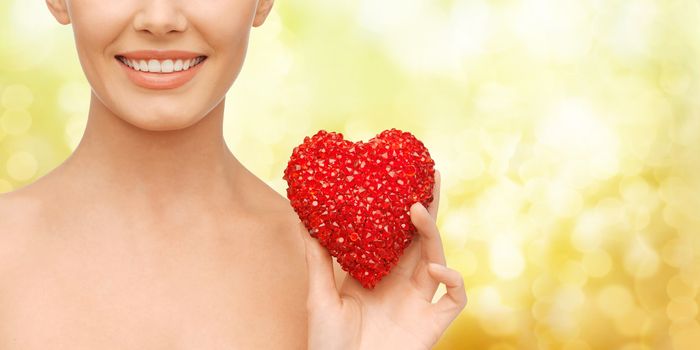 health, beauty and charity concept - beautiful woman with red heart