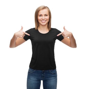 t-shirt design, happy people concept - smiling woman in blank black t-shirt pointing her fingers at herself