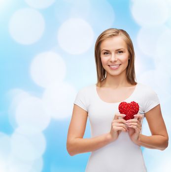 happiness, health and love concept - smiling woman in white t-shirt with heart