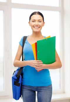 education and school concept - smiling female student with folders and bag at school