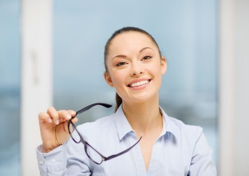 business and education concept - laughing businesswoman with eyeglasses