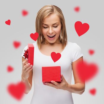 holidays, love, happiness and valentines day concept - beautiful girl with gift box and flying red hearts
