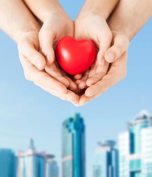 family, love and relationships concept - closeup of woman and man hands with heart