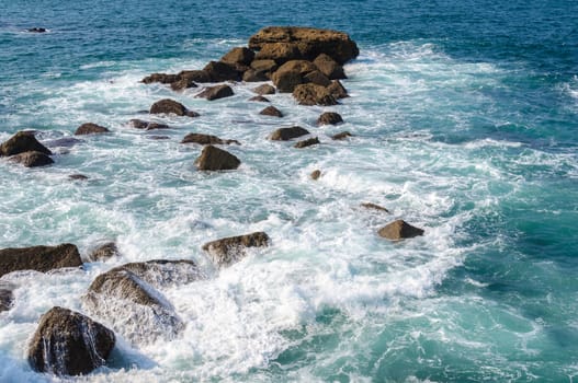 Sea water breaking on rocks