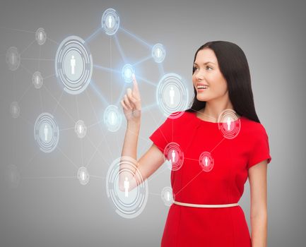 business, communication and future technology concept - attractive young woman in red dress pointing her finger at business network