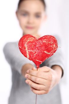 Cute Caucasian girl holding a red Valentine heart