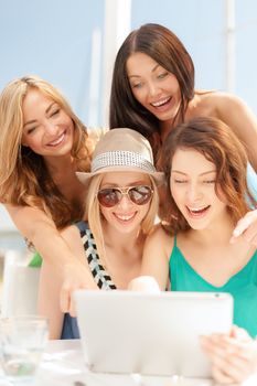 summer holidays, vacation, internet and technology concept - smiling girls looking at tablet pc in cafe