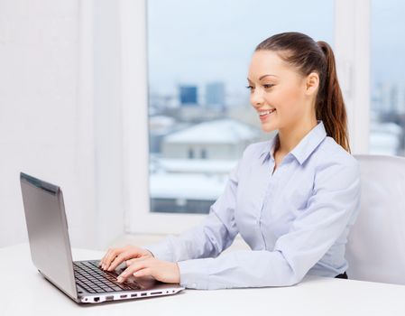 business and technology concept - businesswoman with laptop in office