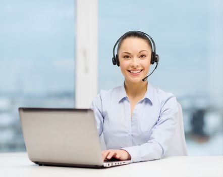 business, communication and call center concept - friendly female helpline operator with headphones and laptop computer