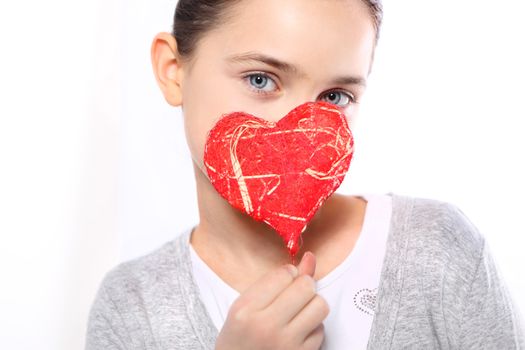 Cute Caucasian girl holding a red Valentine heart