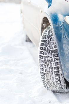 transportation, winter and vehicle concept - closeup of car winter tire