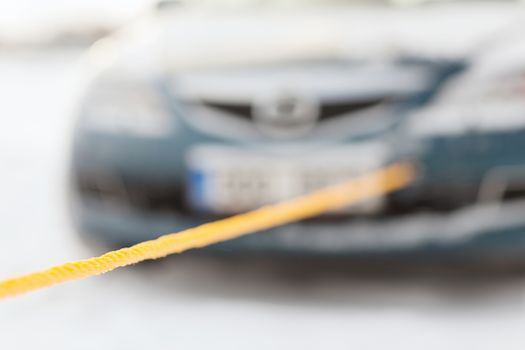 transportation, winter and vehicle concept - closeup of towed car with towing rope