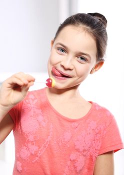 Young girl in a pink shirt with lollipop