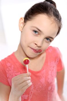 Young girl in a pink shirt with lollipop