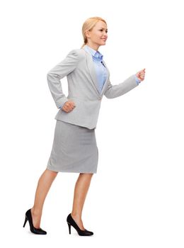 business and education concept - friendly young smiling businesswoman running