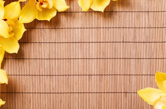 spa, health and beauty concept - closeup of orchid flowers on bamboo mat