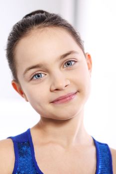 Face of a beautiful young Caucasian girl in a blue dress on a white background