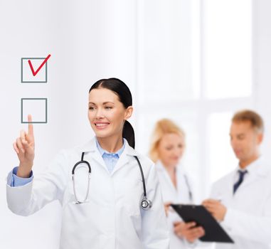 healthcare, medicine and technology concept - smiling female doctor pointing to checkbox