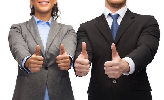 business and office concept - businessman and businesswoman showing thumbs up