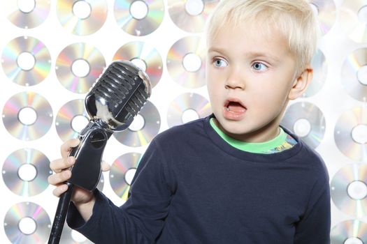 Small, pretty boy singing to microphone