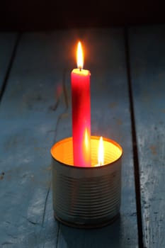 glowing candle in an empty tin can