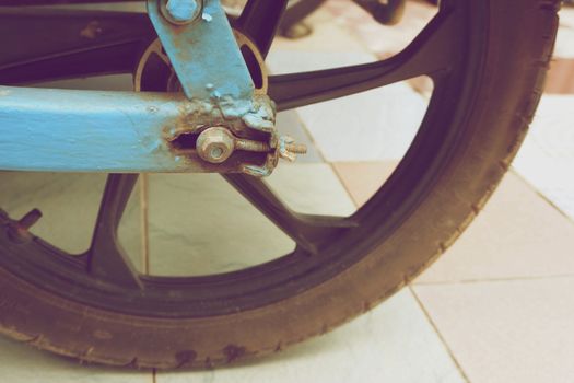 Old bolt and wheel of motorcycle trailer in vintage style.