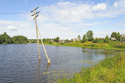 Electric pole in water during a river flood. Country landscape