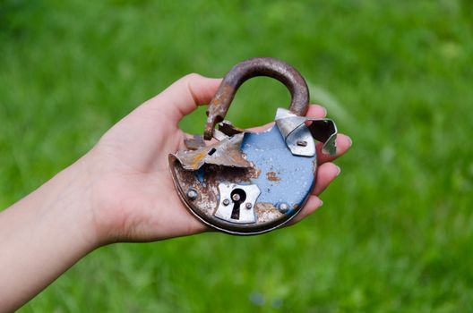 close up of old rusty broken door lock on man hand outdoor