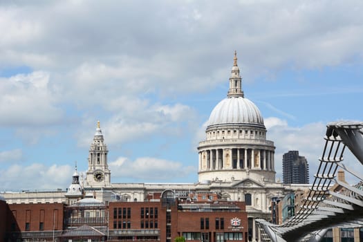 London, UK - May 25, 2014: St Paul's Cathedral and City of London School seen from South Bank on May 25, 2014. The Millennium Bridge on the right allows pedestrians to cross the Thames.
