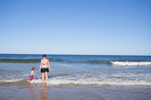 Mother and son playing in the water at the sea