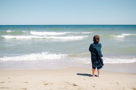 Boy standing on the beach and relaxing in Cape Cod