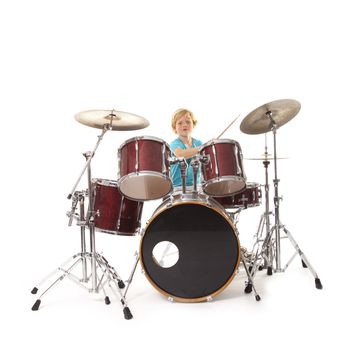 young boy playing drums against white background