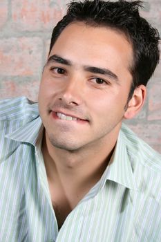 Brunette male model against a brickwall background