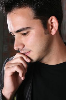 Brunette male model against a brickwall background