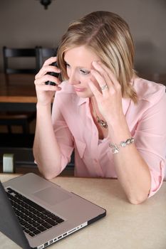 Beautiful blond female working from home on her laptop