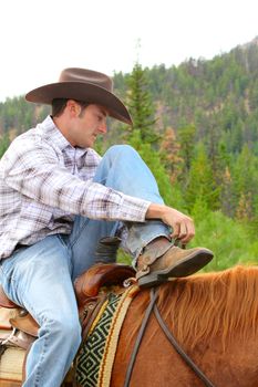 Young cowboy riding his horse in the field 