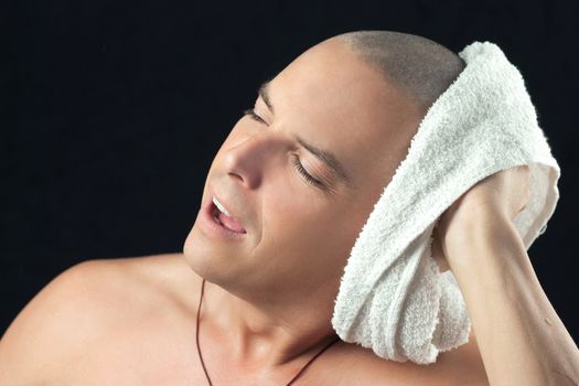 Close-up of a man towel drying his newly shaved head.